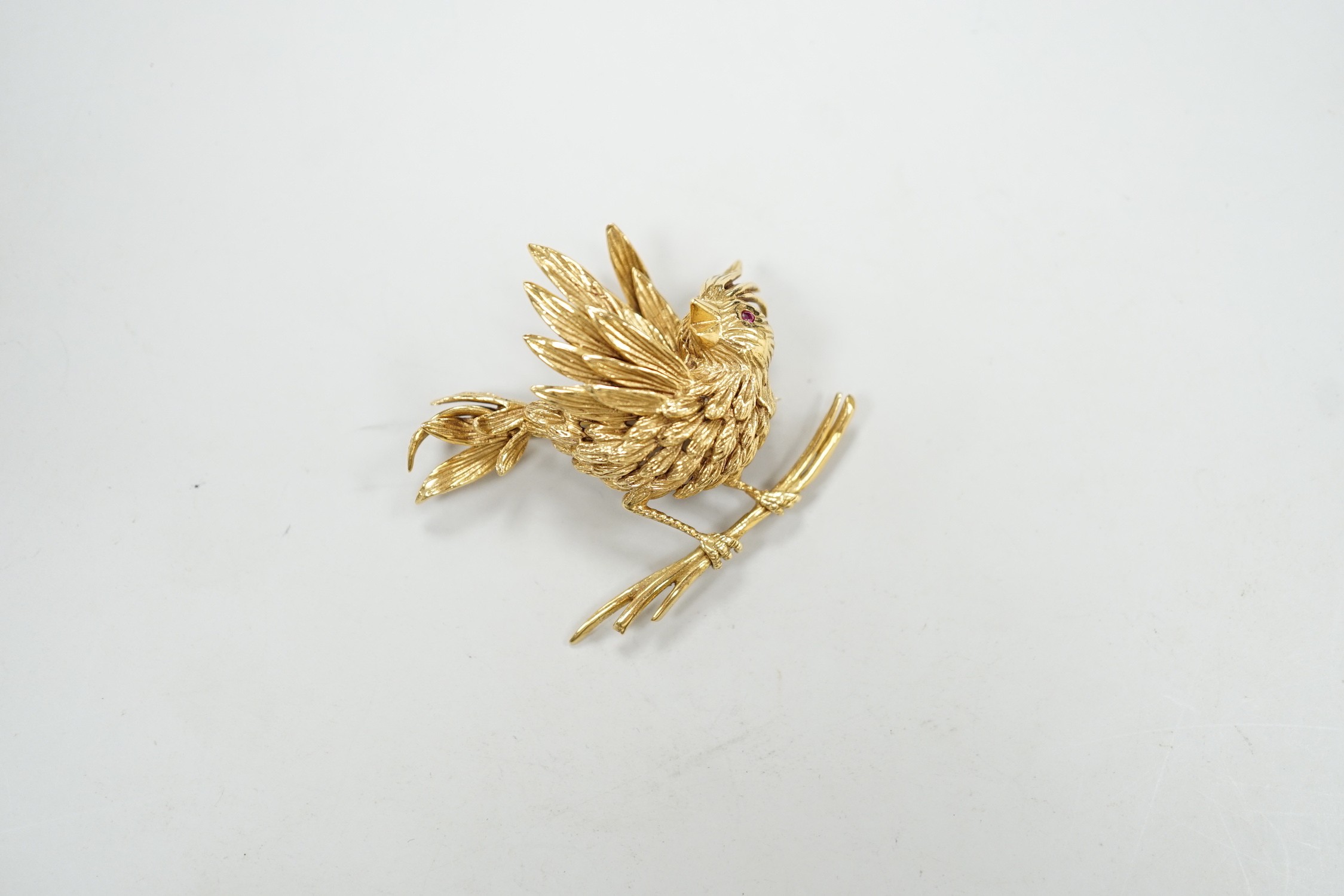 A 1960's Boucheron of Paris 18ct gold and ruby set brooch, modelled as a bird upon a branch, signed, width 43mm, gross weight 20 grams, with Boucheron box.